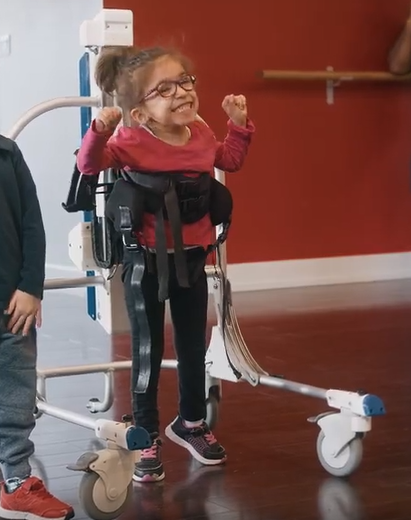 A child dancing while supported by the Levity
