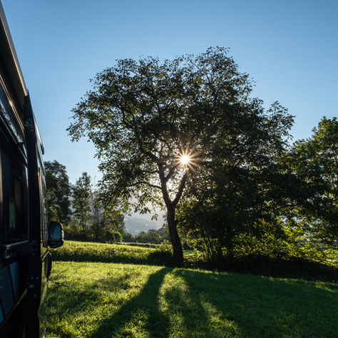 Ein Wohnmobil mit Ackerwiese und Sonne