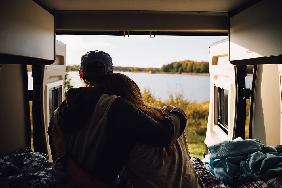 Paar sitzt in Camper und schaut auf See