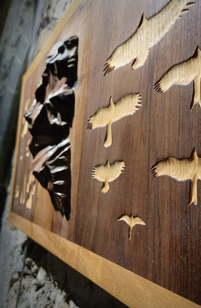 Sculpture sur bois (noyer, érable) représentant les empreintes d'animaux et les silhouettes de rapaces vivant dans les Alpes.
