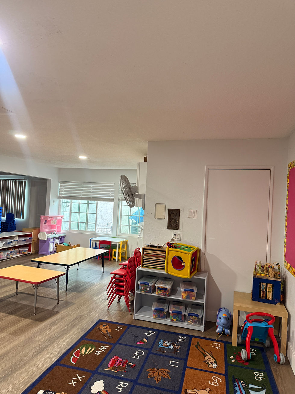 Room 2: Tables, carpet, and toys.