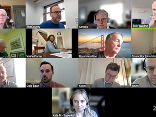 Video call with 12 people in various settings, some with headphones. Labels show names. A virtual background displaying a bridge is visible.