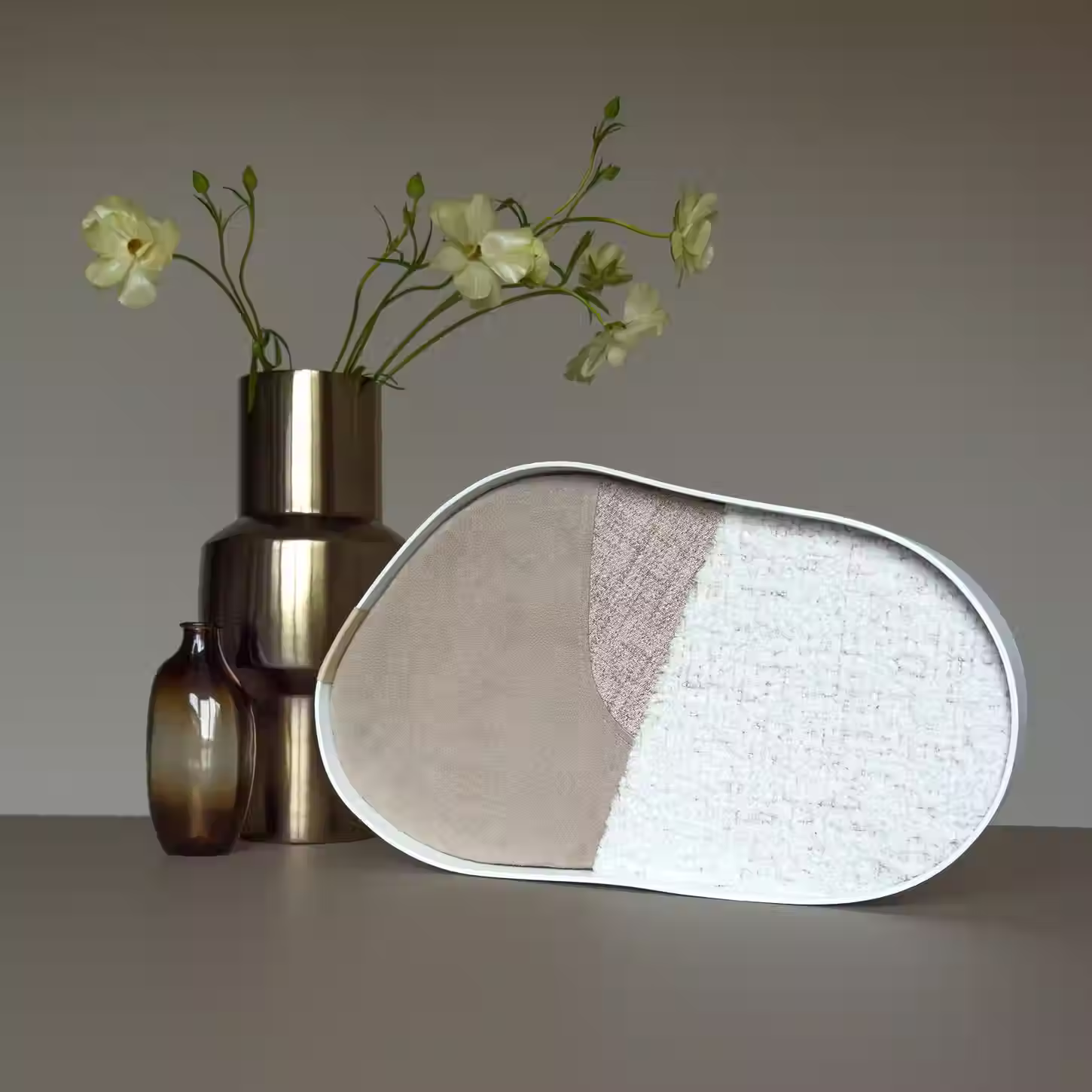 handgemaakt organisch gevormd kunstwerk met natuurlijke tinten en witte lijst op tafel met vaas