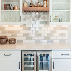 Small tile backsplash between white kitchen cabinets and counters