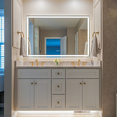 Bathroom vanity with a large mirror and pale countertop