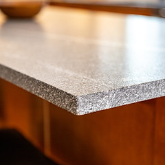 Close-up of a speckled countertop above wood cabinetry