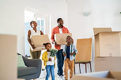 family coming into house with boxes