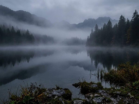 Stiller Bergsee im Morgennebel bei Rosenheim – Eine glatte Oberfläche über unsichtbarer Tiefe als psychologisches Symbol für Spiritual Bypassing. Praxis Patrick Georg, Psychotherapie Rosenheim.
