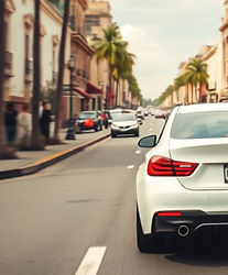 white car driven on a beautiful street of mexic0 shot at a 30 degree angele from the back.