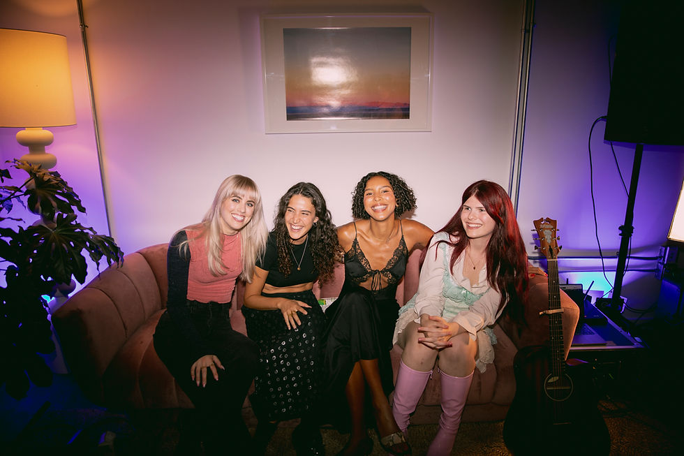 Zealyn, founder of Push-Up Bra LA featured on couch of femme musicians at a showcase for Push-Up Bra LA. 