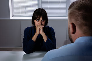 Man Sitting In Front Of Sad Worried Young Woman Suffering From Depression Looking Away.jpg
