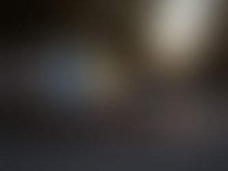 A chiropractor's cargo van parked on a quiet tree-lined suburban street at golden hour, rear doors open with a portable treatment table visible inside, warm evening light, nobody in frame, sense of quiet purpose and movement.