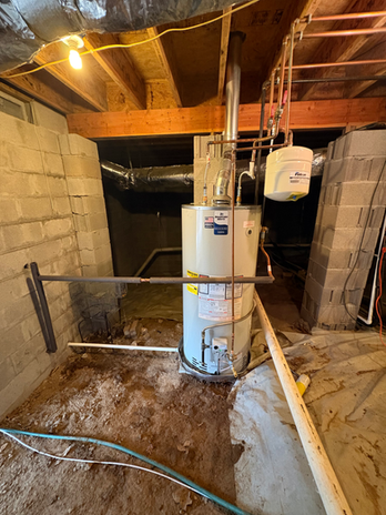 Water heater installed with copper piping in a basement crawl space