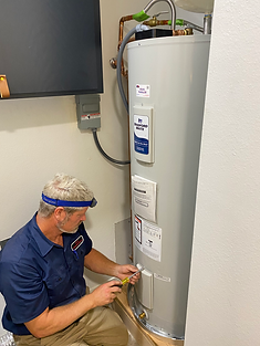 Plumber servicing a Bradford White water heater in a garage