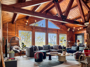 Skypine lodge great room windows mountain view stone fireplace modern design cozy couches rafters