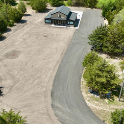 New construction home showing asphalt milling driveway and topsoil grading