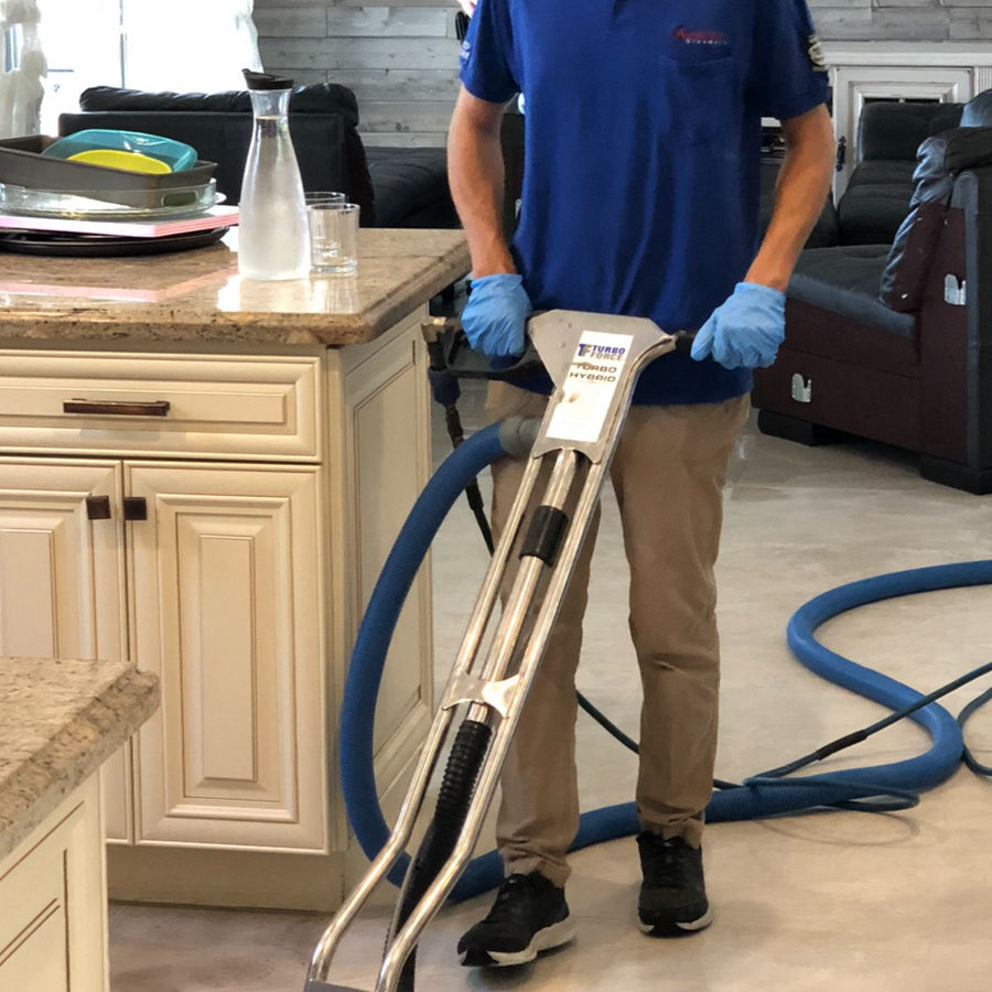 American Steamers technician cleaning a tile floor in a kitchen