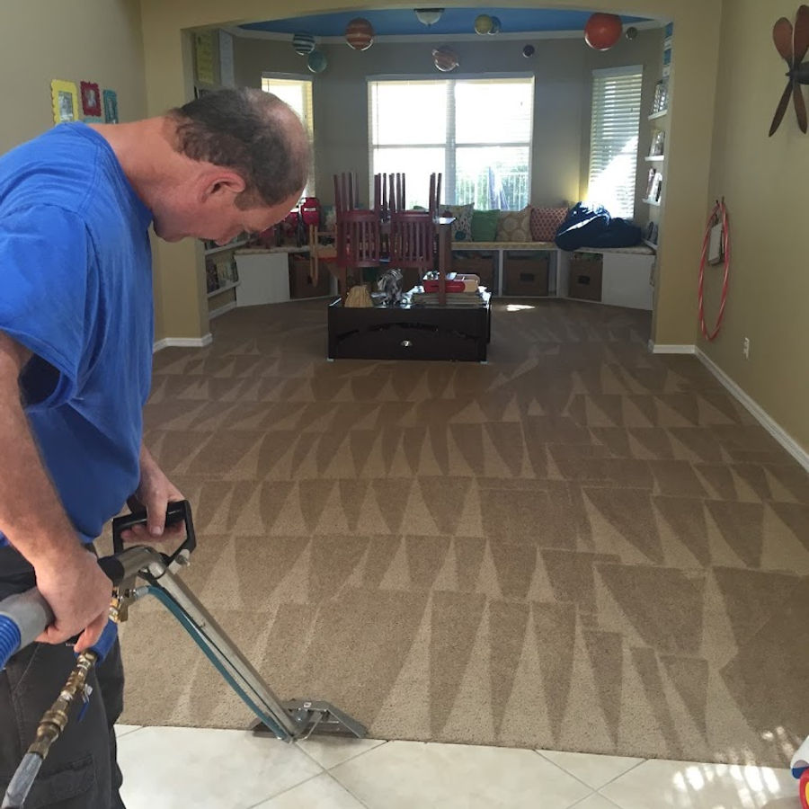 American Steamers technician steam cleaning carpet in a family room