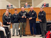 Group of people hold an award. E 9-1-1 is in the photo.