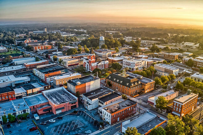 An arial view of Statesboro Georgia, in the evening with the sunset shining on tops of buildings