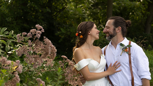 couple smiling at each other in lush greenery at fairwinds farm by still poetry photography in north east maryland