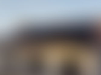 Maison individuelle moderne à Orléans en Centre-Val de Loire avec toiture en tuiles plates équipée de 16 panneaux solaires photovoltaïques noirs alignés, installation solaire résidentielle en autoconsommation sous lumière de fin d’après-midi, environnement pavillonnaire français.