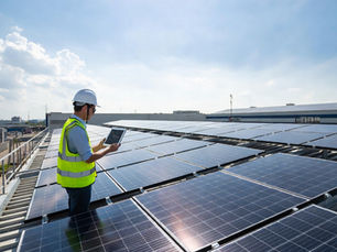 Ingénieur en énergie observant une grande installation de panneaux solaires photovoltaïques sur la toiture d’un bâtiment industriel moderne, tablette numérique affichant données de production énergétique, zone industrielle en arrière-plan, panneaux solaires brillants au soleil, photographie ultra réaliste technique d’infrastructure énergétique durable et énergie renouvelable pour entreprises B2B