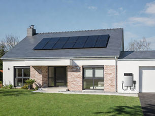 Installation photovoltaïque maison moderne Orléans France : panneaux solaires + batterie domestique lithium fixée au mur du garage, concept autonomie énergétique et énergie renouvelable