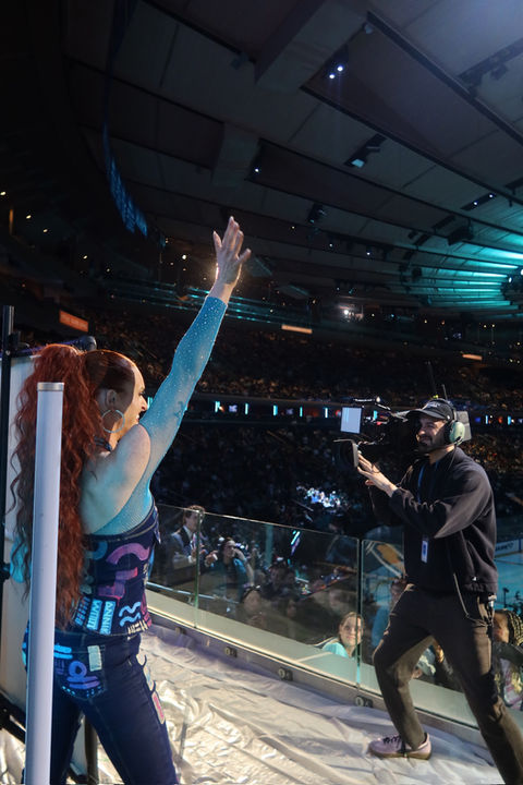 Annika Wooton posing with a custom live speed painting created for the PWHL New York Sirens at Madison Square Garden — the first sold-out women's hockey game in MSG history