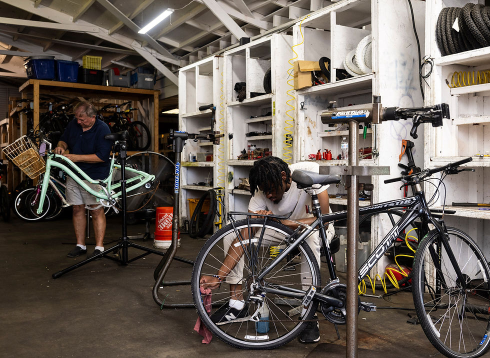 Two individuals repairing donated bicycles during our Earn a Bike program.