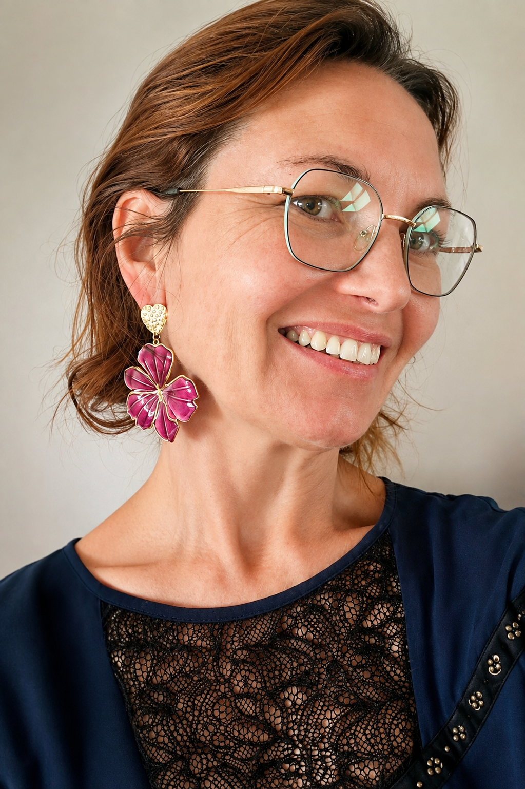 Boucles d'oreilles fleurs fuchsia portées, clous dorés en acier inoxydables