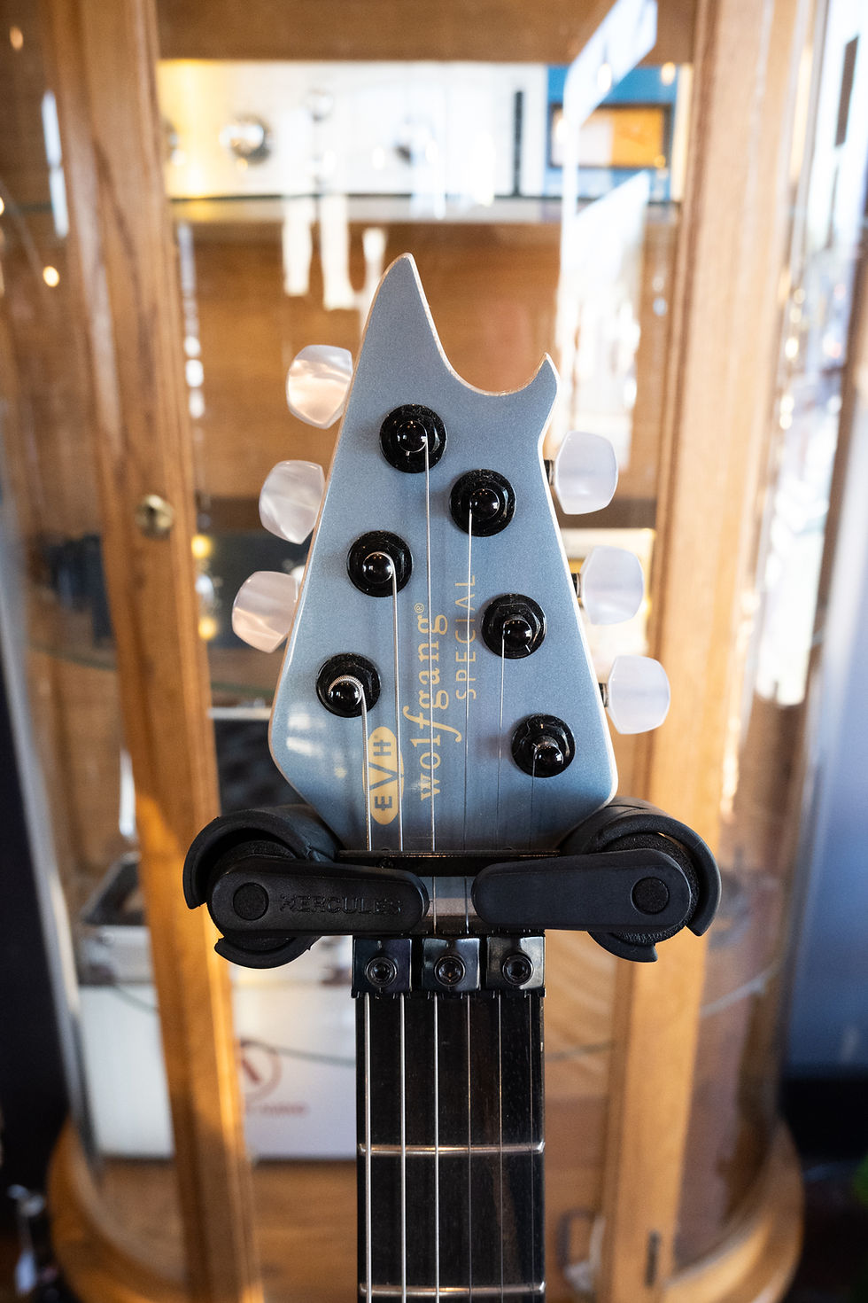 Thumbnail: The headstock of a metallic blue six string guitar.