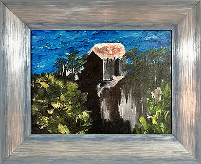 This small painting features a rustic structure—possibly an old stone house or ruin—with a reddish-brown roof set against a vibrant, textured blue ocean. Surrounding the building are lush green trees and foliage.