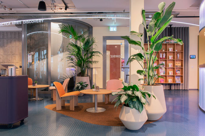 Diese stilvolle Büro-Lounge kombiniert modernes Design mit üppigen Pflanzen und schafft eine entspannte Atmosphäre für Meetings und Pausen. Großzügige Grünpflanzen verbessern die Luftqualität und fördern das Wohlbefinden der Mitarbeitenden. Perfekt für Unternehmen, die auf nachhaltige Bürogestaltung und eine inspirierende Arbeitsumgebung setzen.