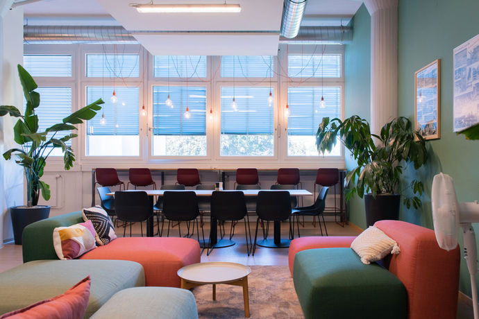 Ein offener, farbenfroher Arbeitsbereich mit integrierter Begrünung fördert Kreativität und Zusammenarbeit. Pflanzen sorgen für ein angenehmes Raumklima und steigern die Produktivität. Ideal für moderne Büros, die Kommunikation und Teamarbeit stärken möchten.