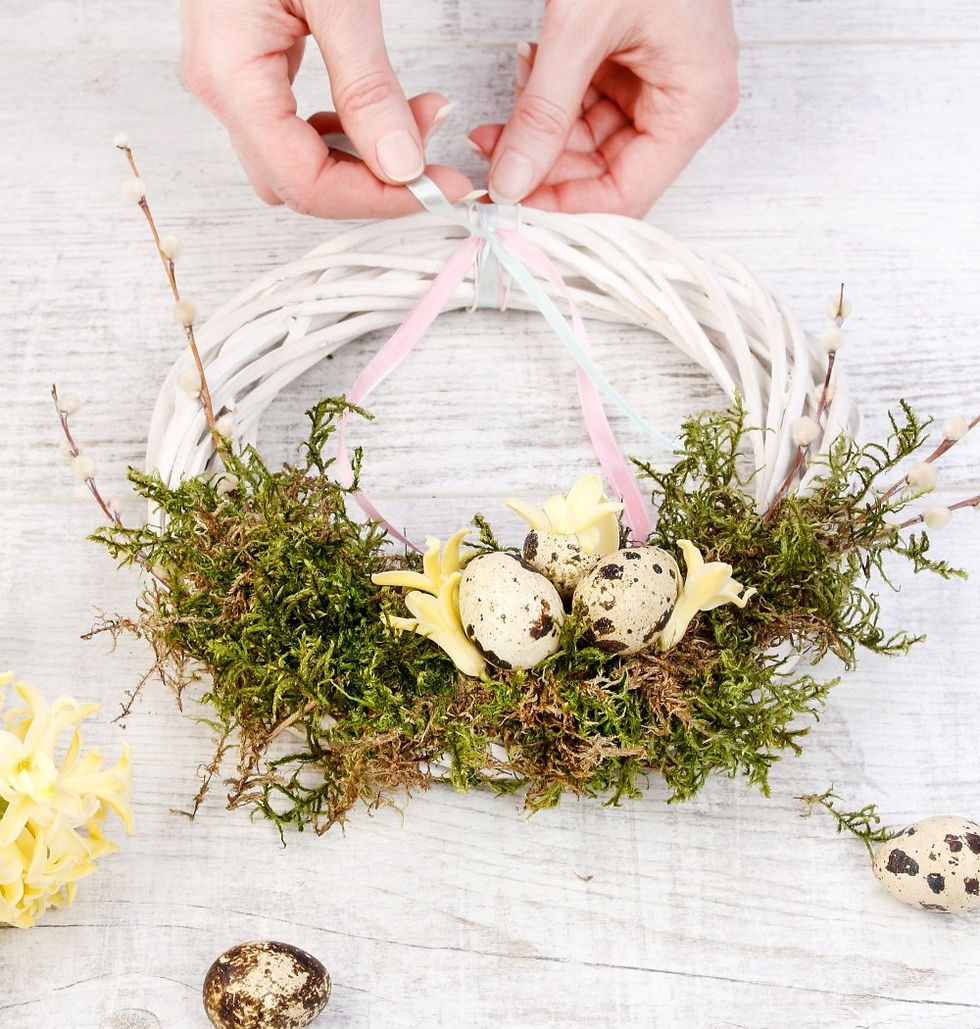 ein weißer Osterkrans mit Moos kleinen eiern und Frühlingsblumen