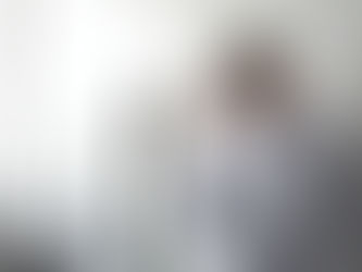 Hombre preocupado apoyado contra una pared en un entorno laboral, reflejando angustia por problemas de cobertura médica o acceso a tratamientos de salud.