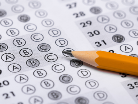 A pencil rests on an ACT answer sheet with filled circles, predominantly marking option D. The sheet shows numbers 16-36.