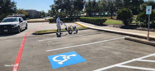 a man is painting a handicapped parking spot in a parking lot