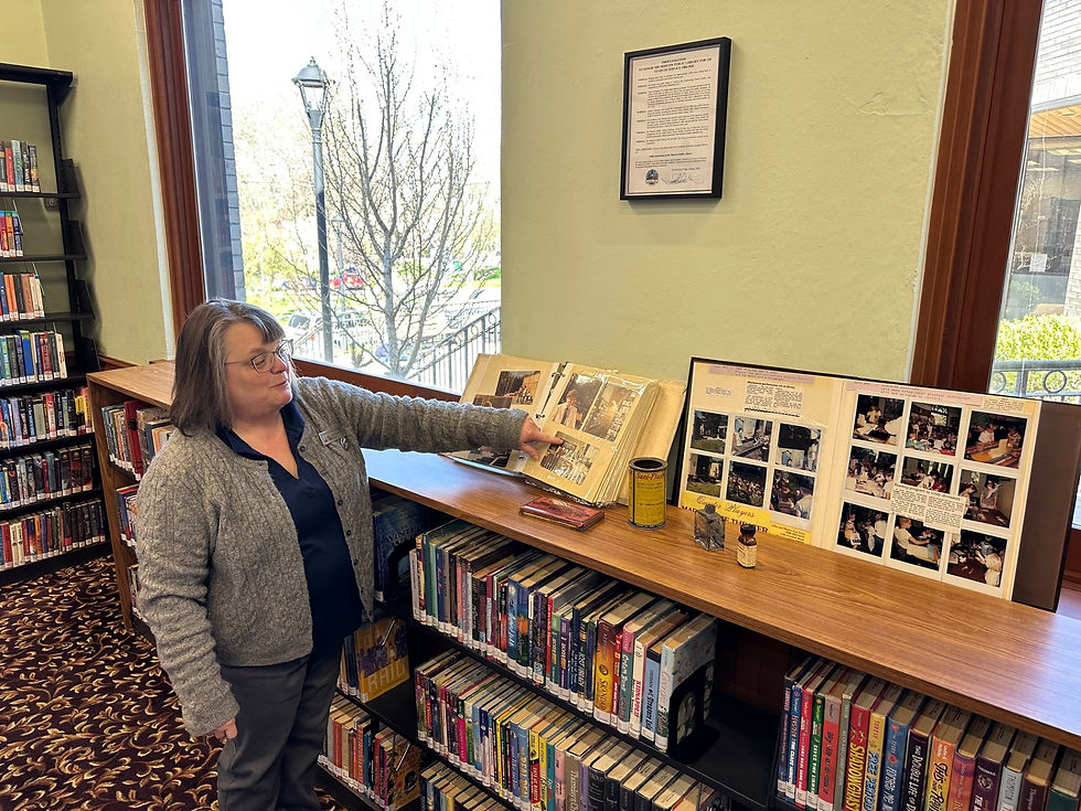 April Hernandez, Latah County Library District director, explaining photos from when the 1980s library was being built.