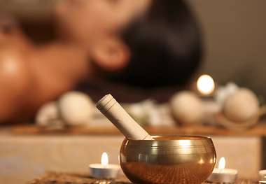 Tibetan singing bowl with aroma candles on table in spa salon.jpg