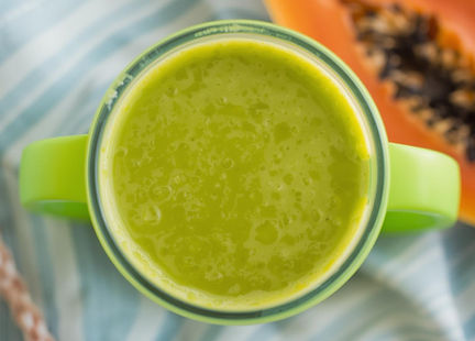 Copa de Campeón tropical smoothie made with mango, papaya, banana, kale, dates, flaxseed, and hemp seeds.