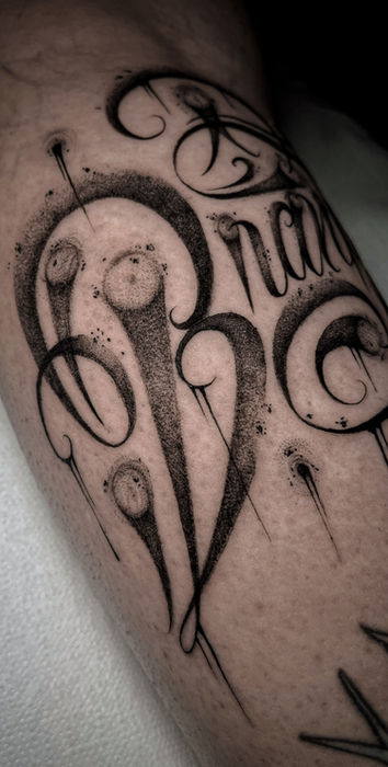 Schwarze Tattoo-Kunst mit dem Wort 'Brain', auf Unterarm von Tätowierer.