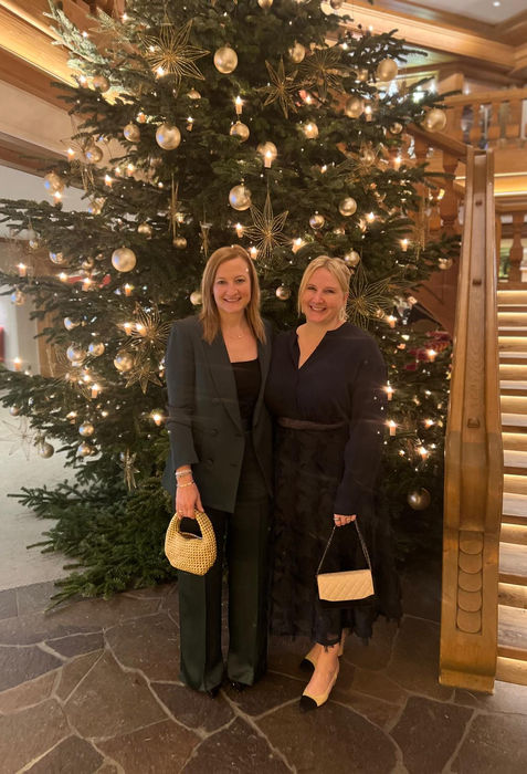 Zwei Frauen posieren vor Weihnachtsbaum