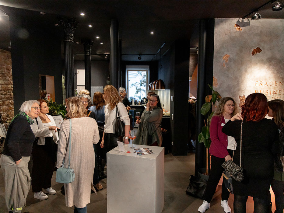 Frauen stehen zusammen in einem Raum, DAS NETZWERK von Frauen&Business. Gespräche und Interaktionen.