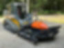 Skid steer with brush hogging service attachment on gravel.
