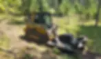 John Deere skid steer providing brush hogging service.