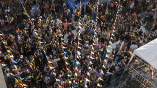 Large crowd gathered at an outdoor festival, many holding colorful water guns, illustrating high crowd density and the need for measurement systems at events and tourist attractions.