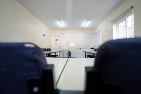 a classroom with a green exit sign on the wall