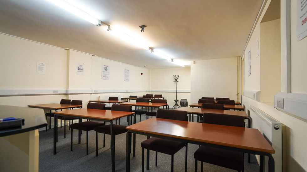Large training room with rows of desks, whiteboard and natural light at My Meeting Space Tottenham
